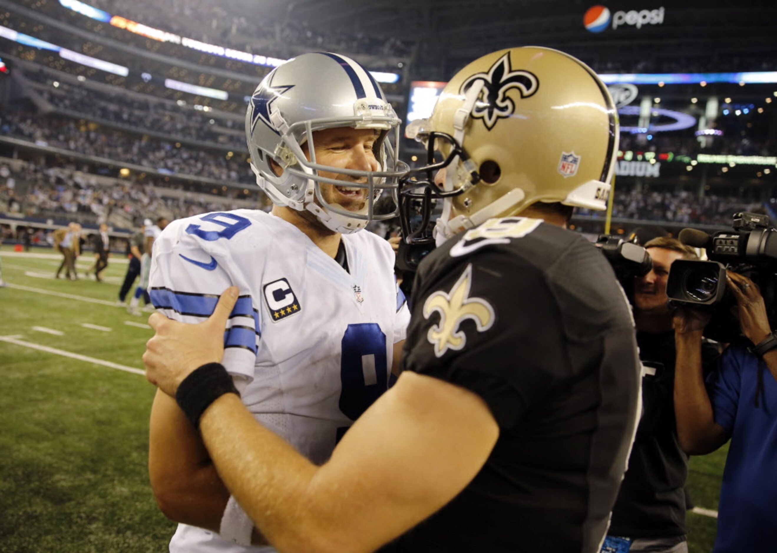 Dallas Cowboys quarterback Tony Romo (9) hugs New Orleans Saints quarterback Drew Brees (9)...