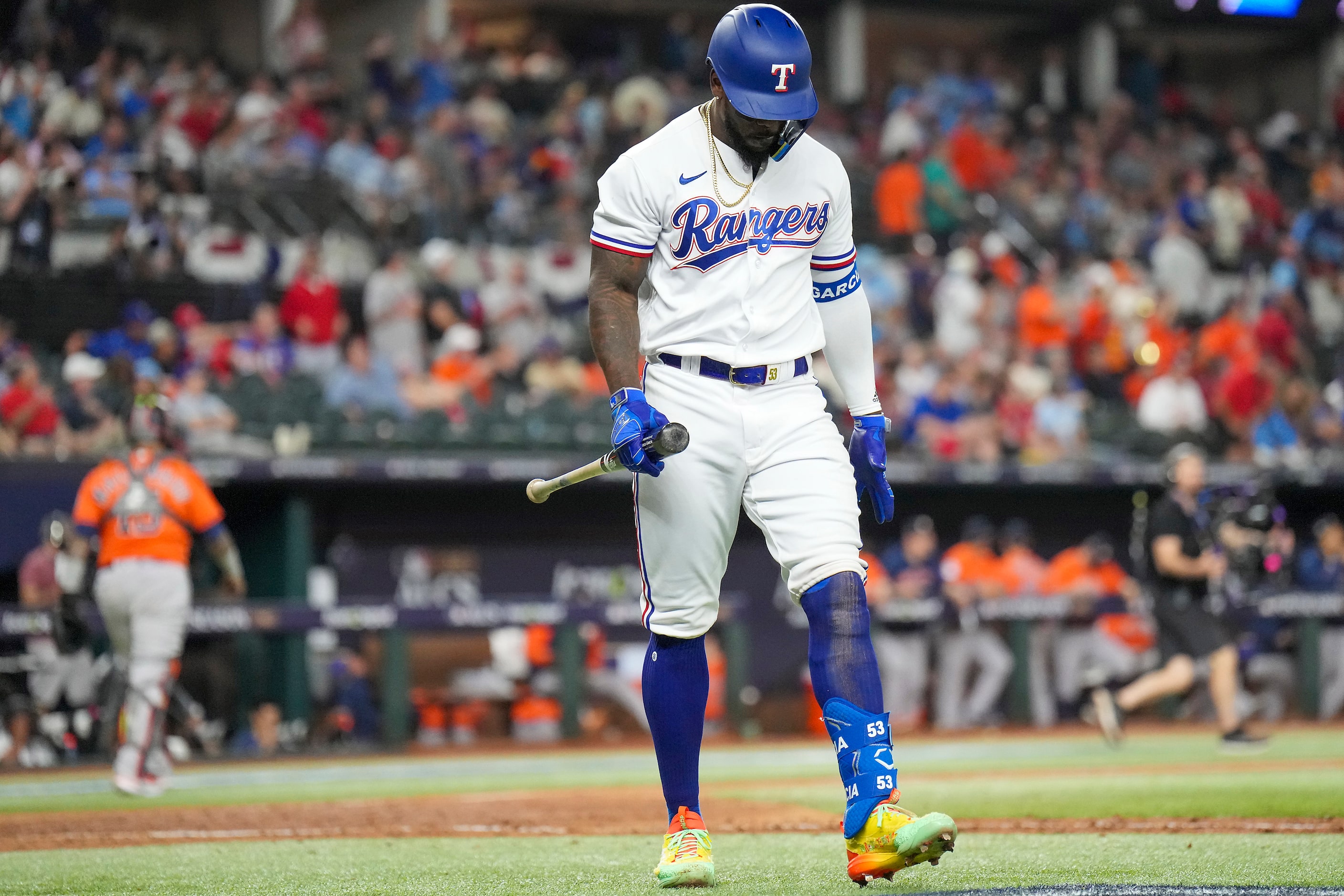 Texas Rangers right fielder Adolis Garcia heads to the dugout after striking out to end the...