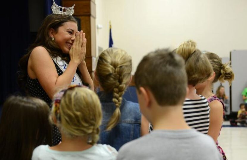 
Monique Evans reacts after students sang her a song during an assembly at Saigling...