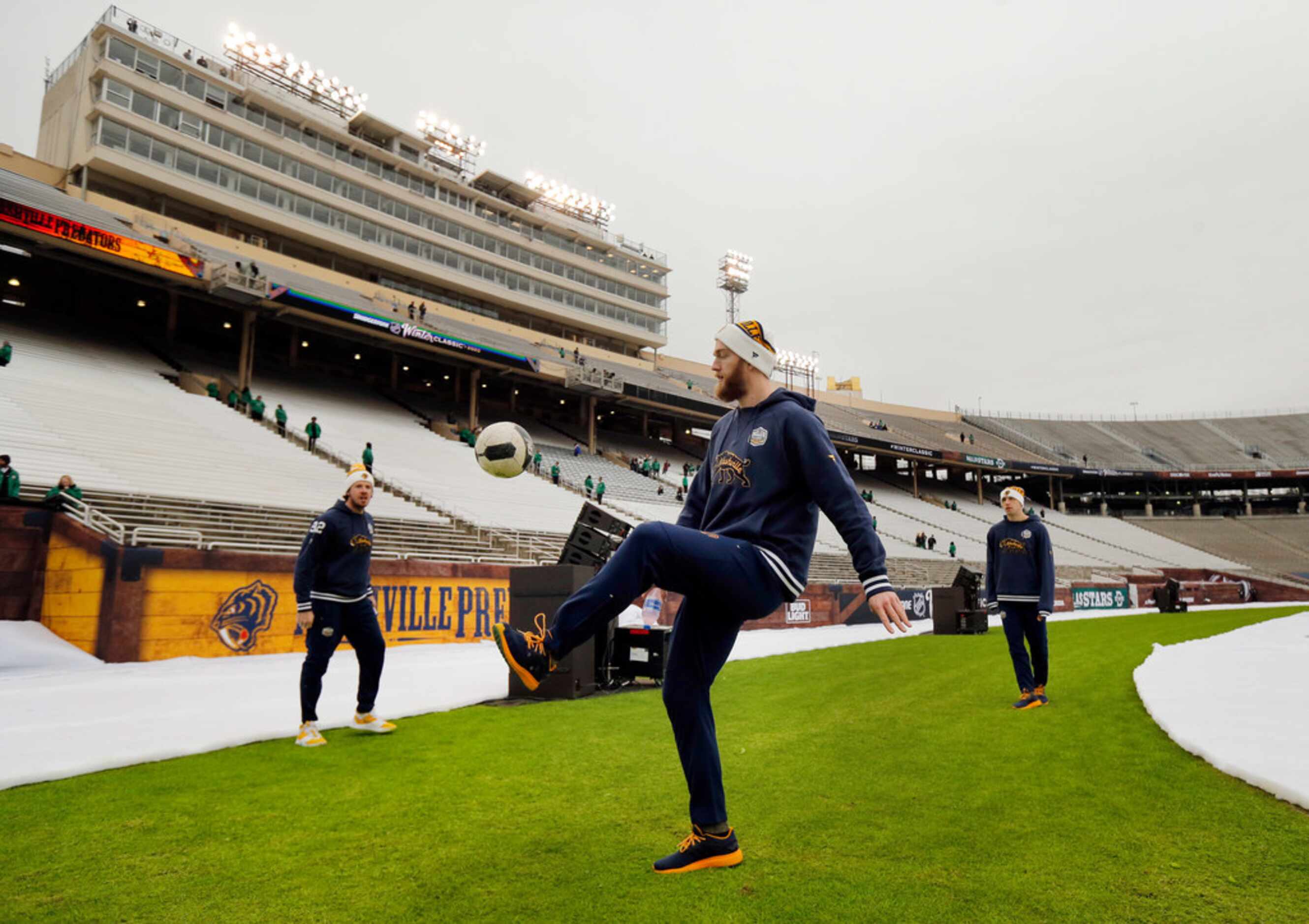 Nashville Predators defenseman Mattias Ekholm (14) kicks a soccer ball with teammates as...