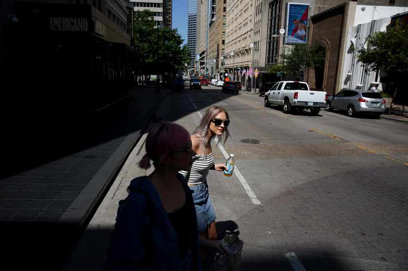 Sisters Sarah Knowlton (left) and Natalie Knowlton walk across Main Street after an...