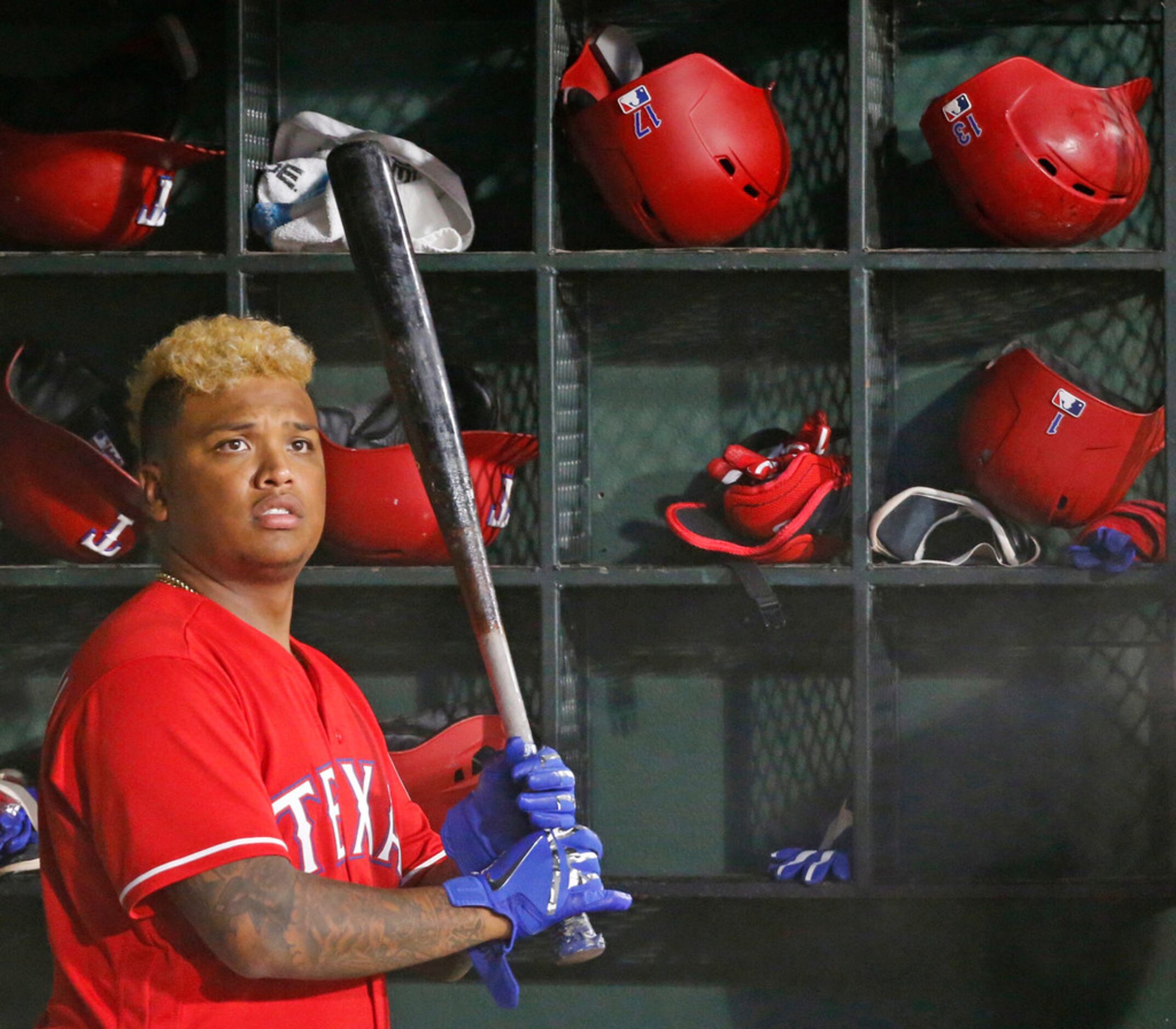 Texas Rangers designated hitter Willie Calhoun (5) waits for an at bat in the dugout in the...