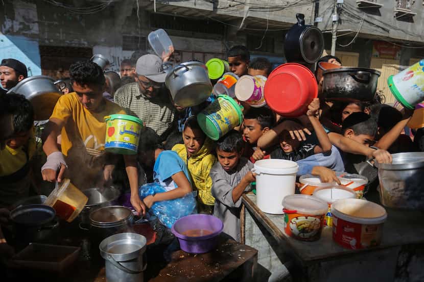 Palestinians crowded together as they wait for food distribution in Rafah, southern Gaza...