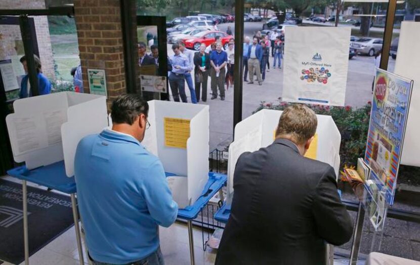 
Bruce Vincent (left) and Patrick Gardner cast their votes at the Reverchon Park Recreation...