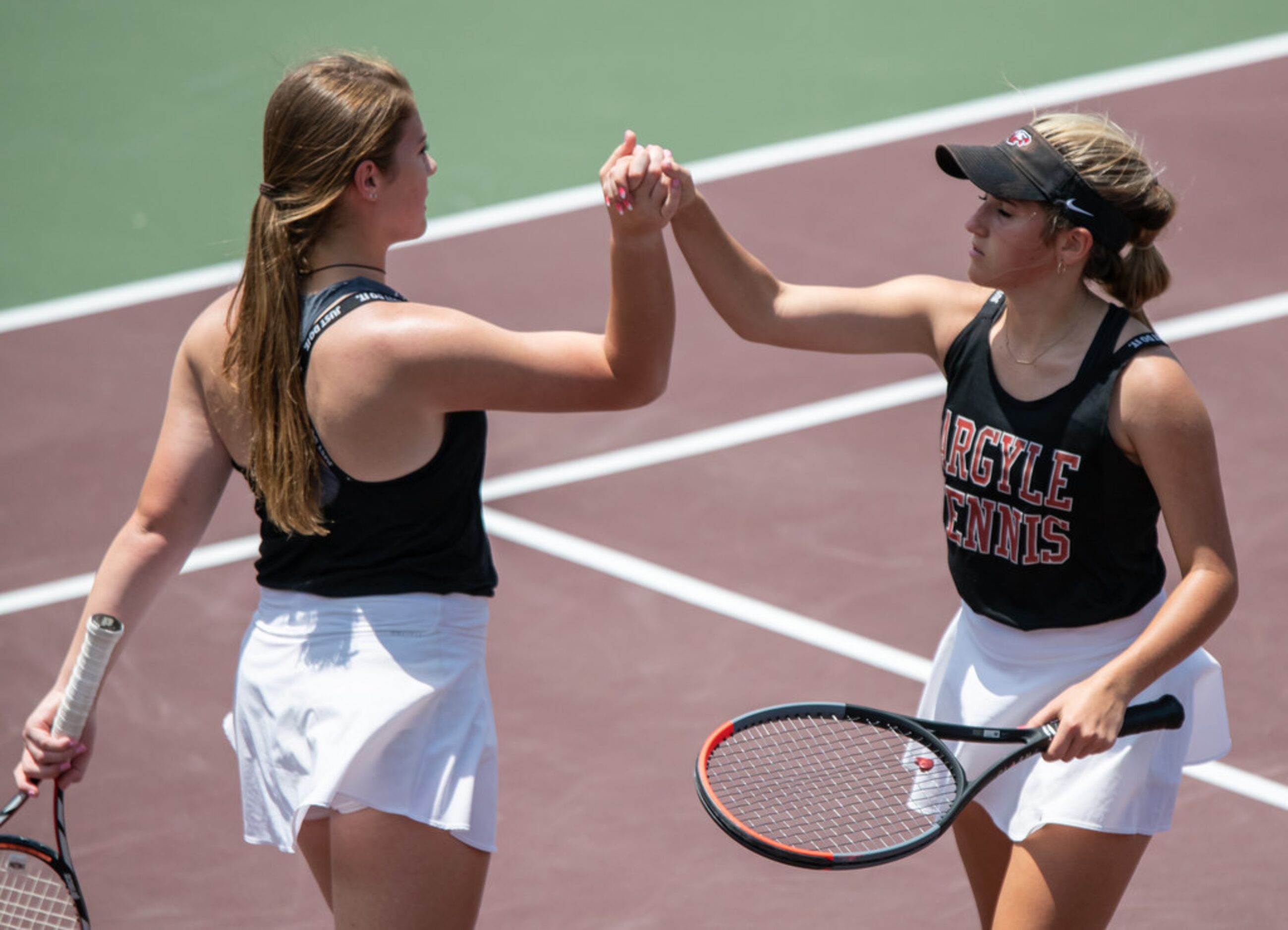 Argyle's Sarah Oellermann and Zoe Zablosky high five during a doubles match against Boerne's...