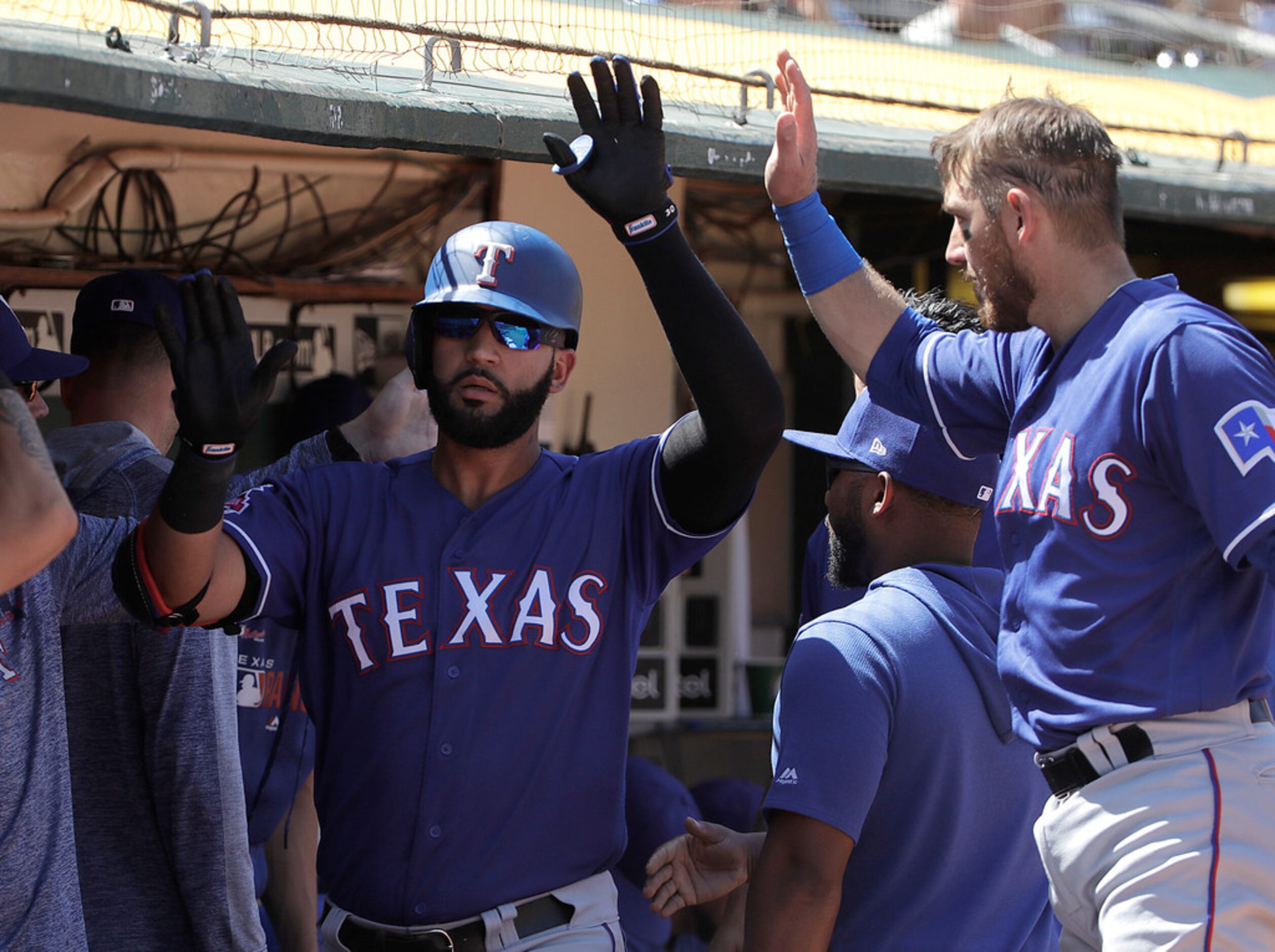 Texas Rangers' Nomar Mazara, center, celebrates with teammates after hitting a solo home run...