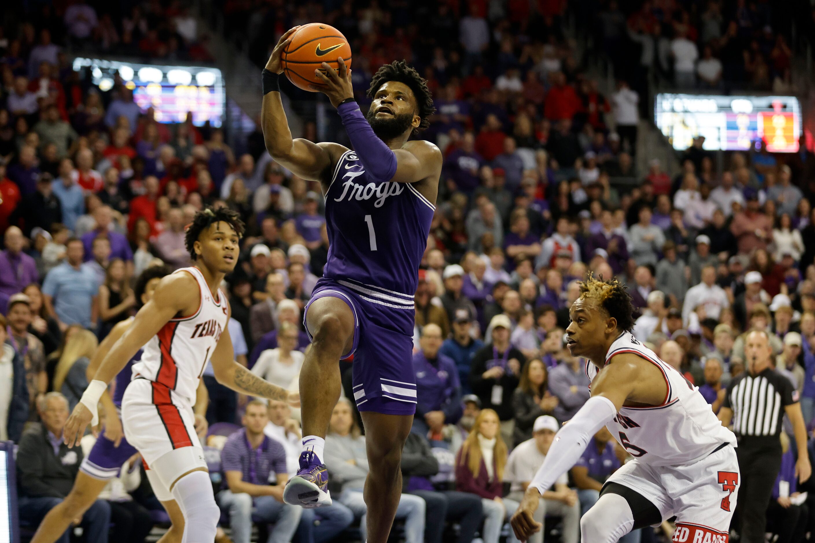 TCU guard Mike Miles (1) goes for a layup in front of Texas Tech guard Terrence Shannon Jr.,...