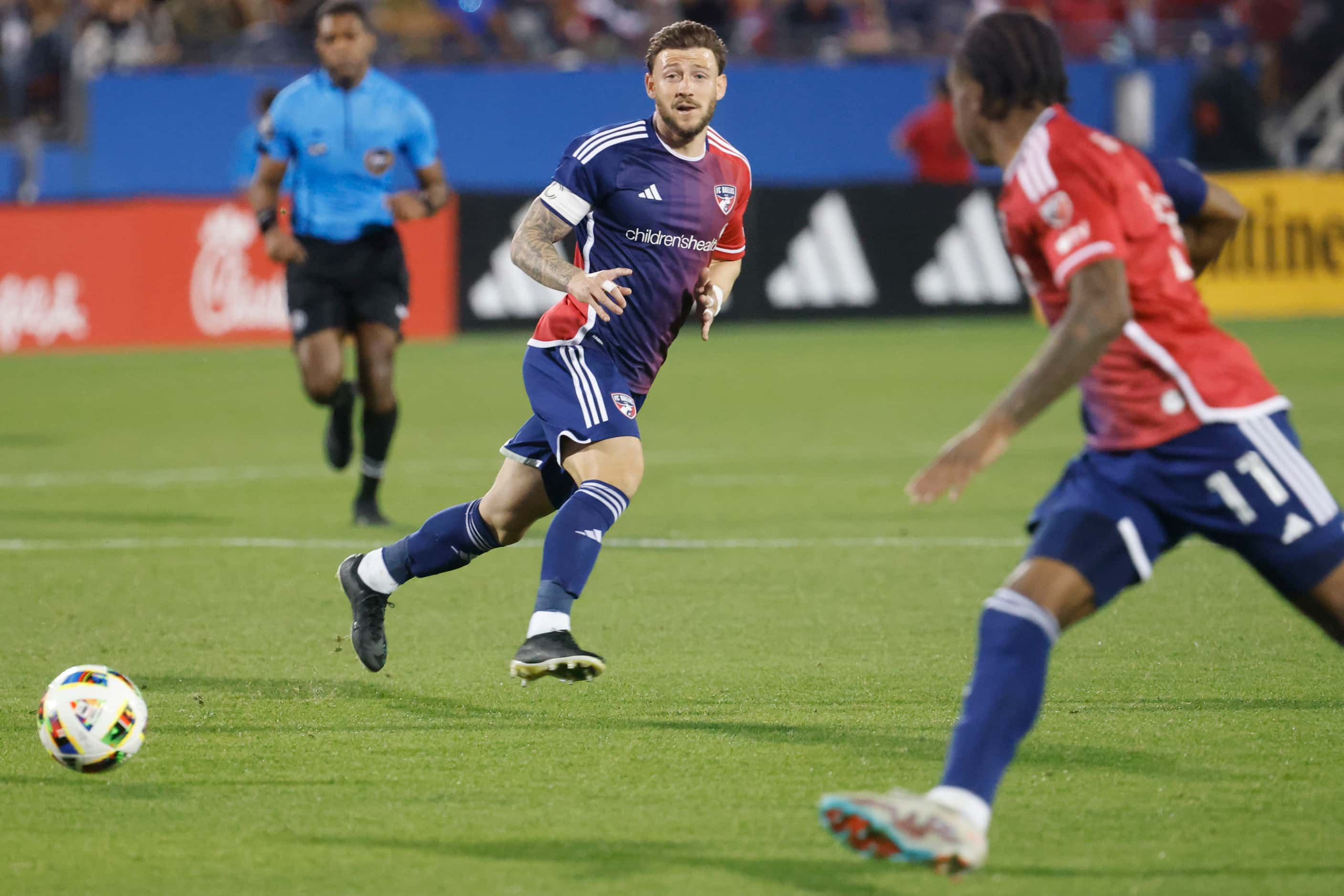 FC Dallas forward Paul Arriola (back) looks as he passes the ball to forward Dante Sealy...