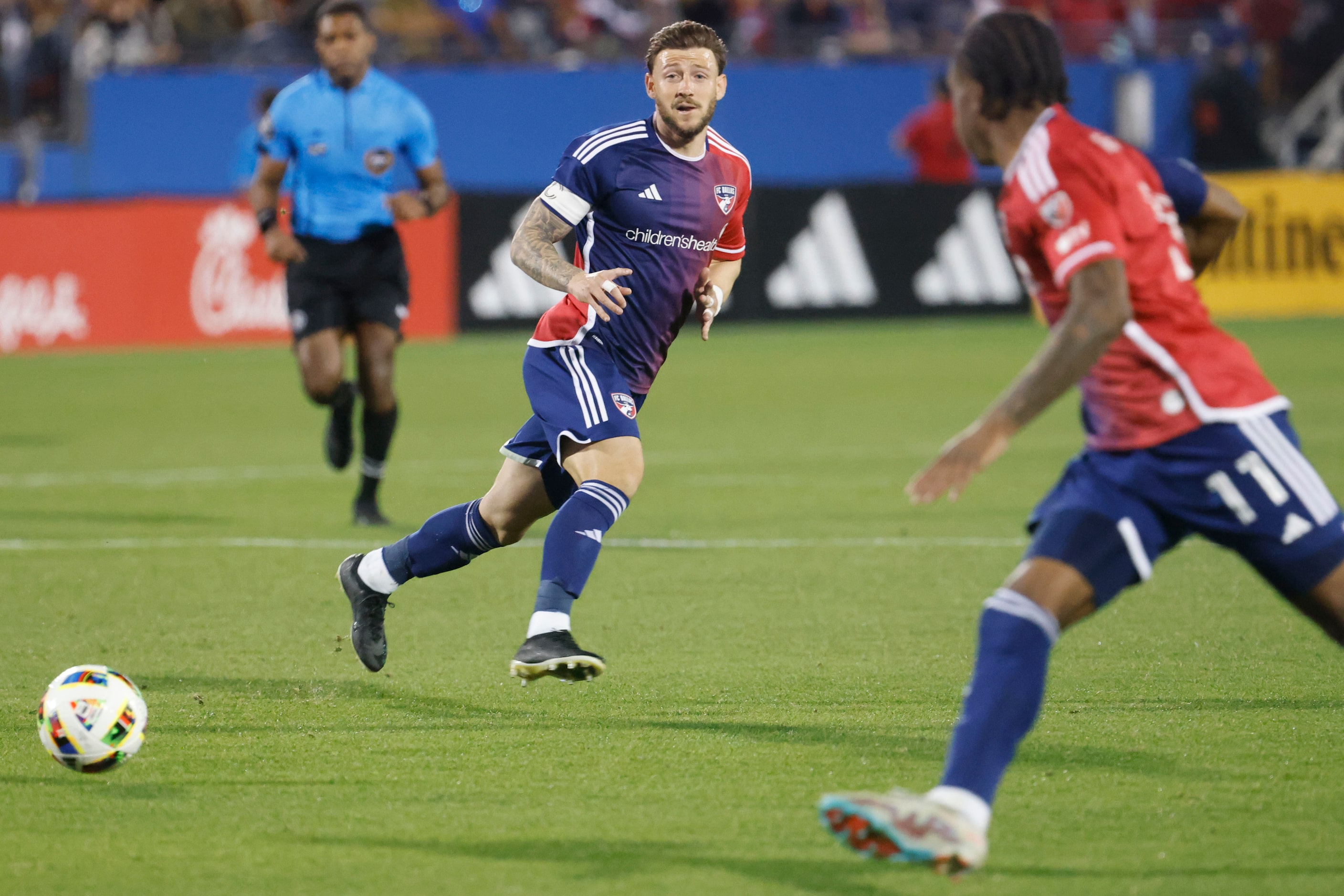 FC Dallas forward Paul Arriola (back) looks as he passes the ball to forward Dante Sealy...