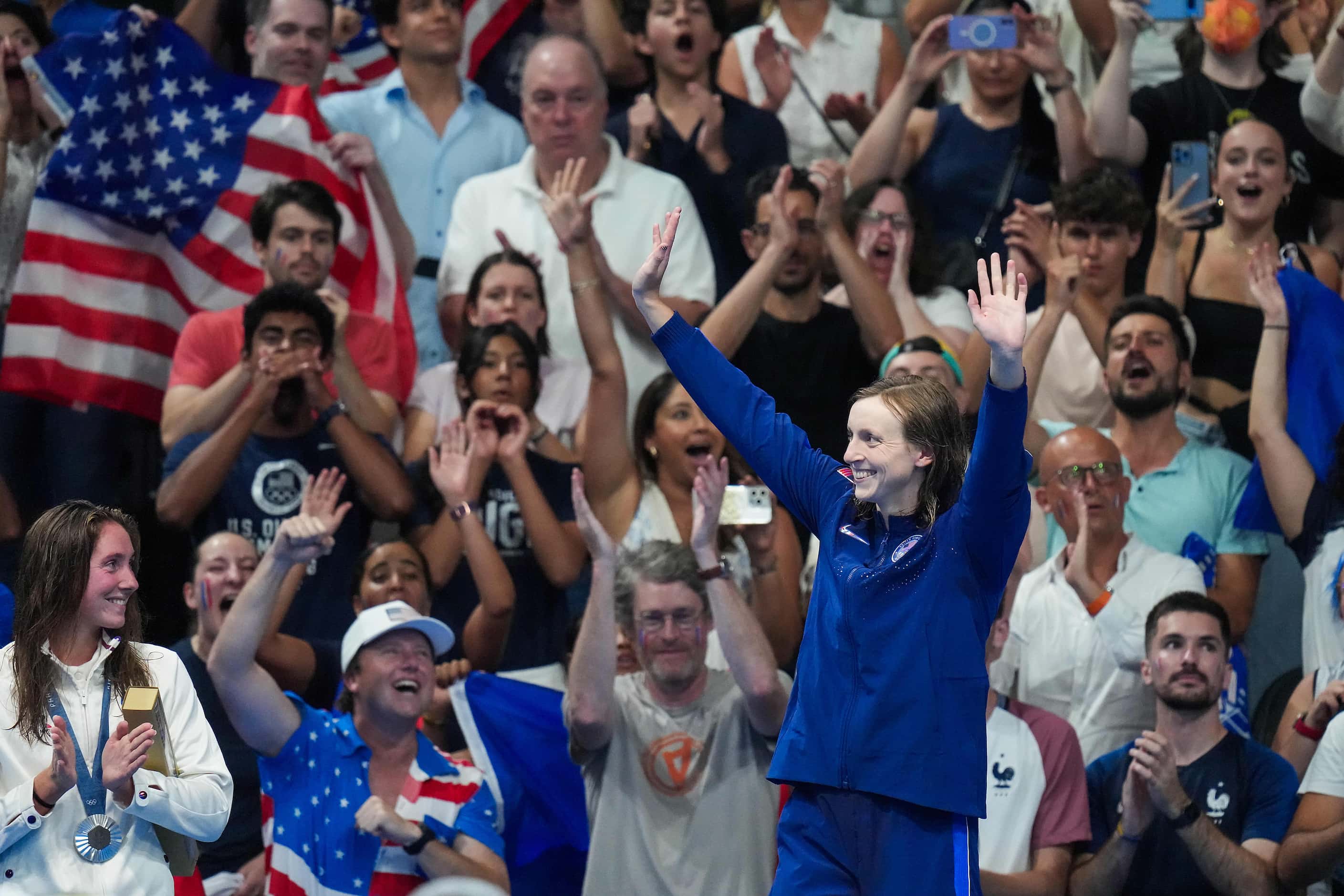 Katie Ledecky of the United States celebrates as she steps the medals podium after winning...