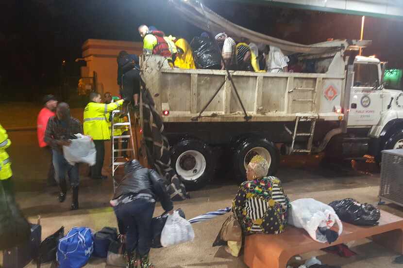 A dump truck pulls into Houston's Kashmere Transit Center with people rescued from Hurricane...