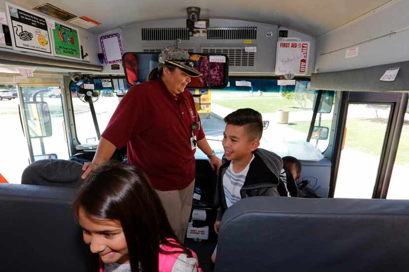 Mesquite ISD bus driver Terri Wallis, center, welcomes students Delilah Lopez, 8,left, and...
