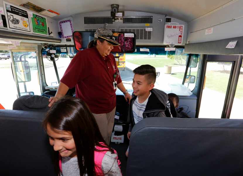 Mesquite ISD bus driver Terri Wallis, center, welcomes students Delilah Lopez, 8,left, and...