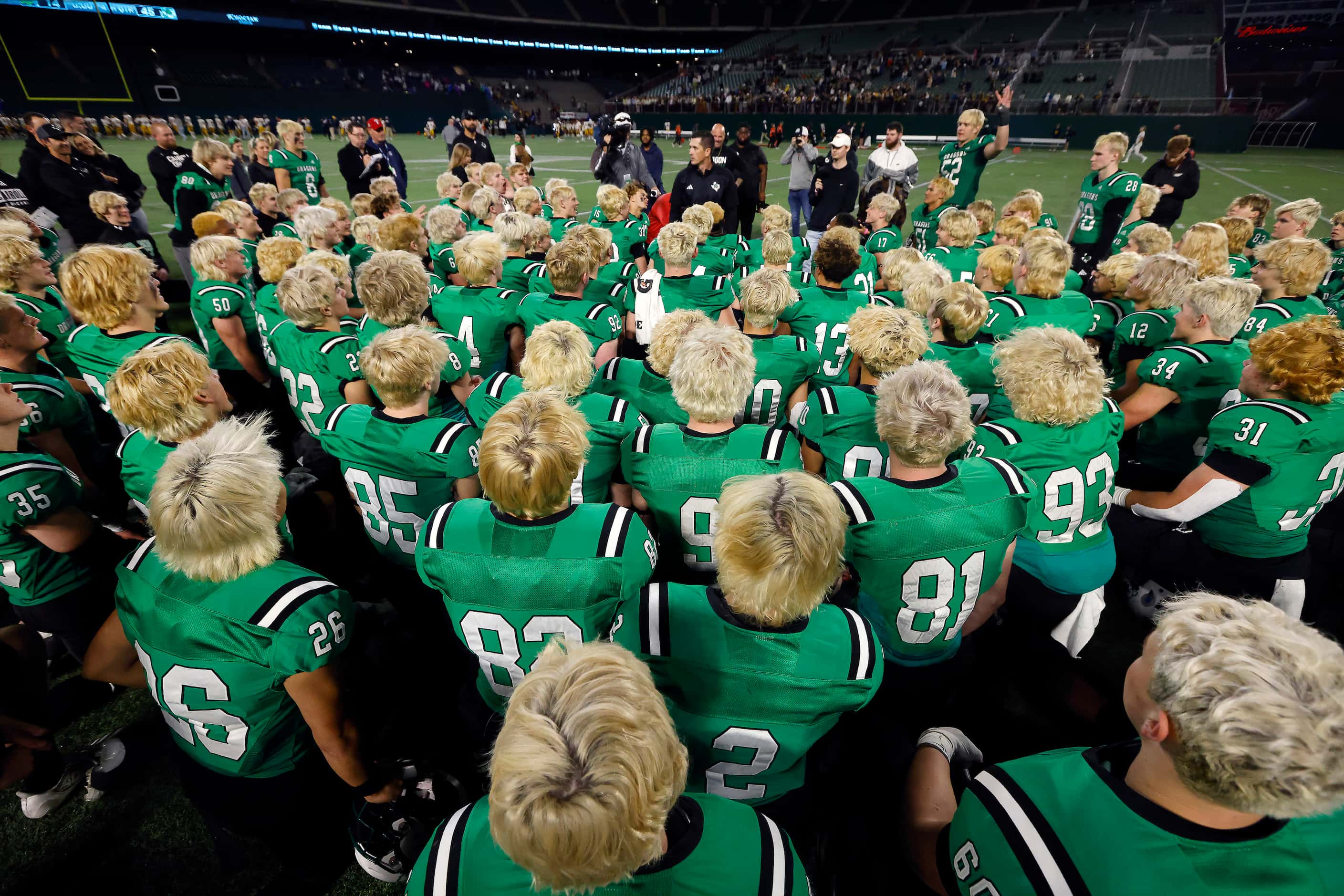 The blond haired Southlake Carroll football team listens to head coach Riley Dodge following...