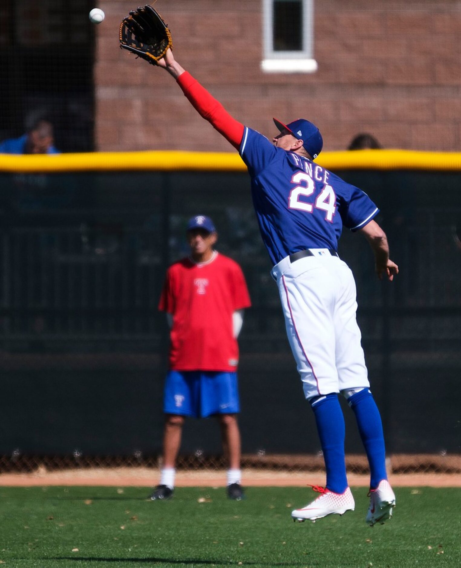 Texas Rangers outfielder Hunter Pence makes a leaping catch in a fielding drill during the...