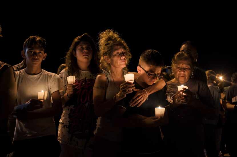 J. Anthony Hernandez, 12, is comforted by his mother, Mona Rodriguez, during a vigil for...