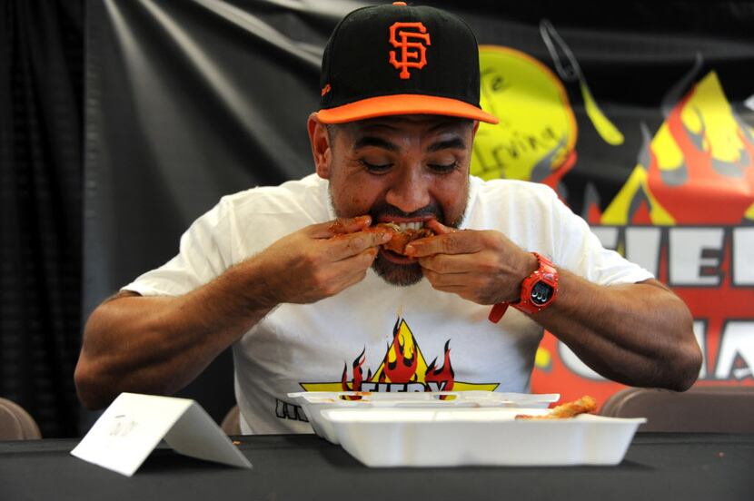 Roman eats wings by Wing Town at the Taste of Irving Fiery Heat Challenge in Irving, TX on...