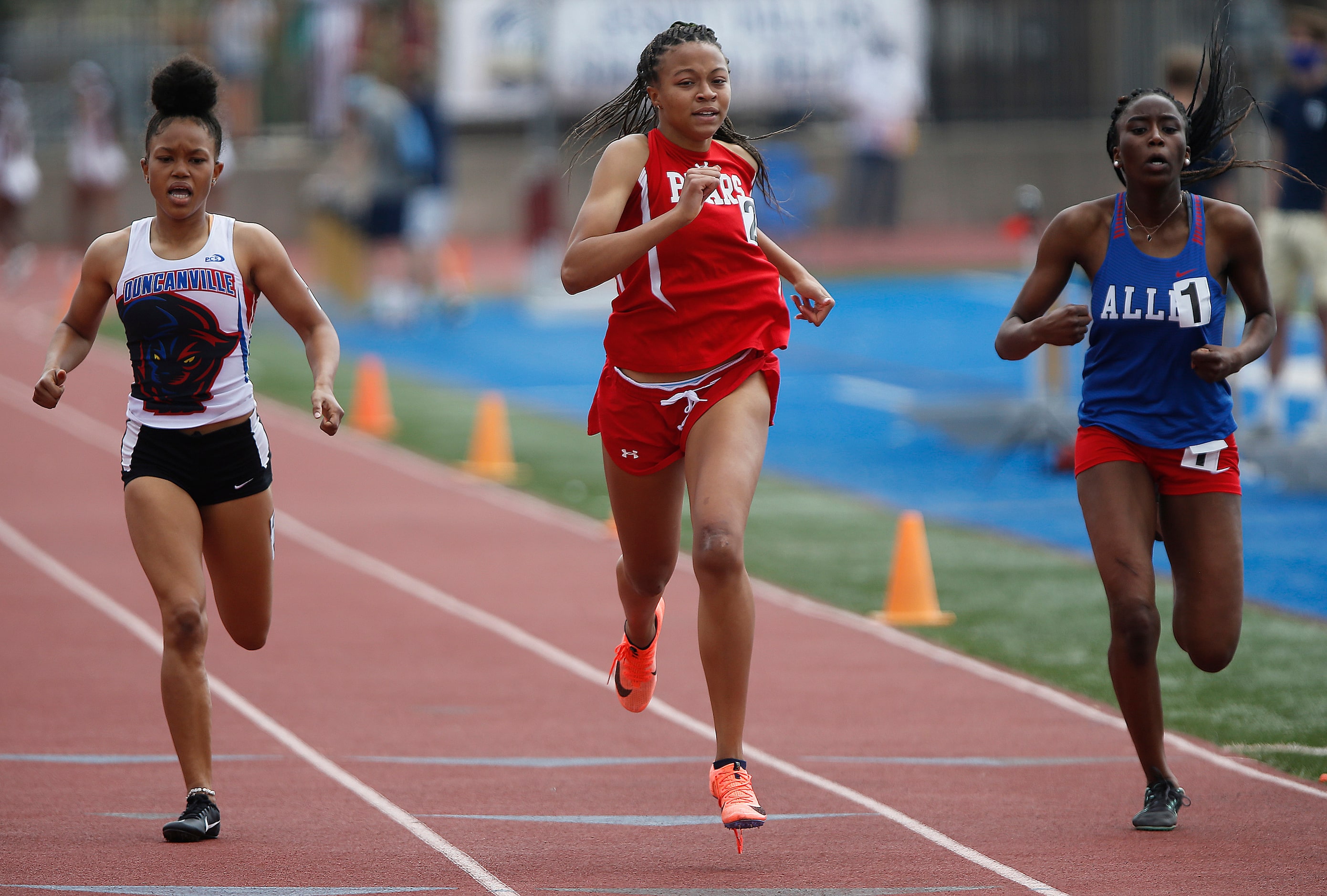 Alyssa Jackson (center), 16, of Ursuline Academy, narrowly finished first in her heat of the...