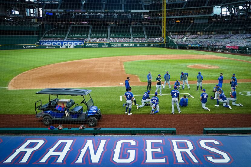 Texas Rangers players gather around field coordinator Matt Hagen following a game at the...