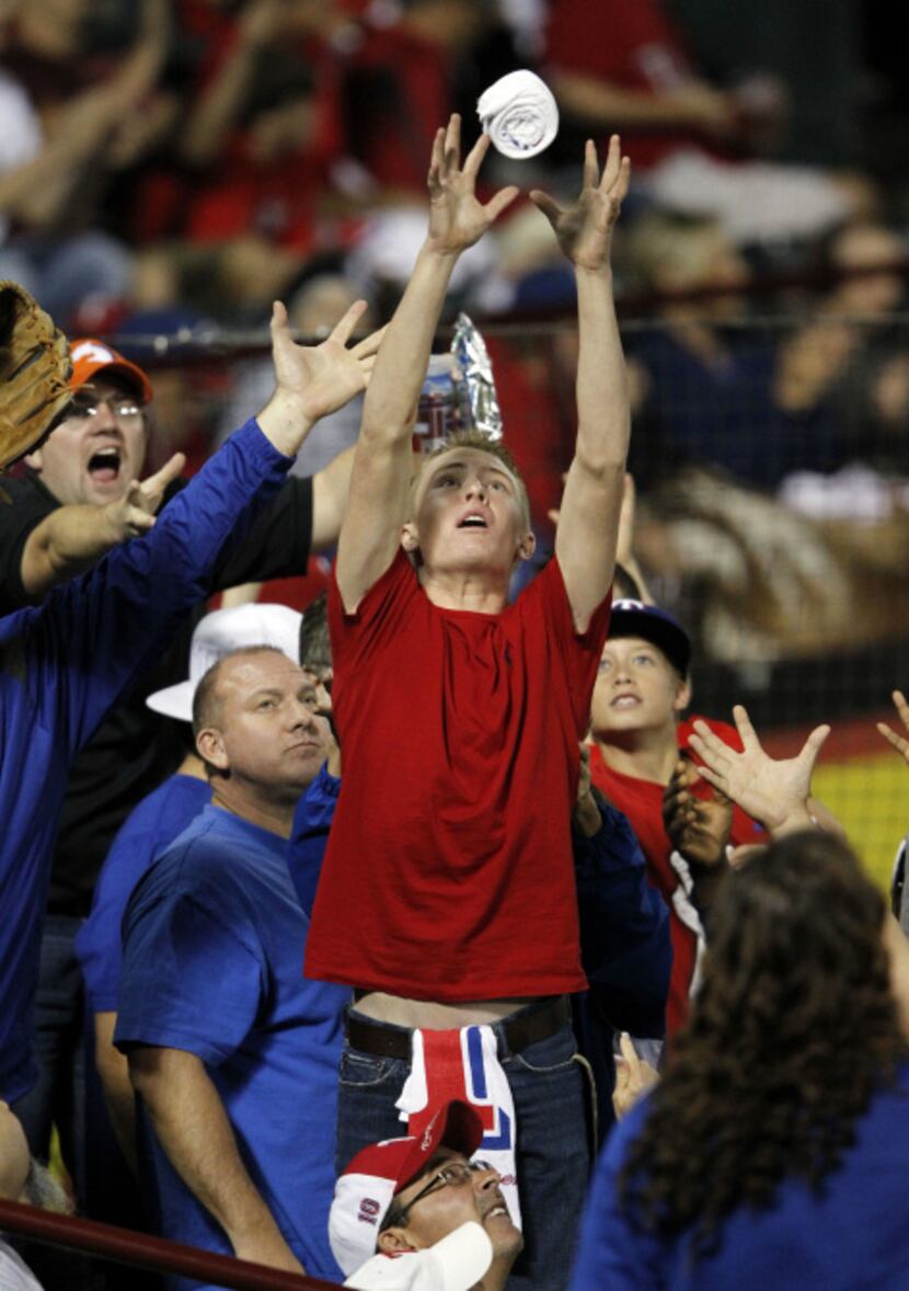 Texas Rangers fans attempt to get free items during a game against the Baltimore Orioles...
