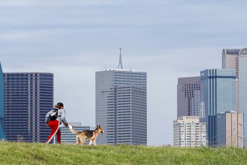 A woman runs with her dog along the Trinity Levee Trail in Dallas on Aug. 18.