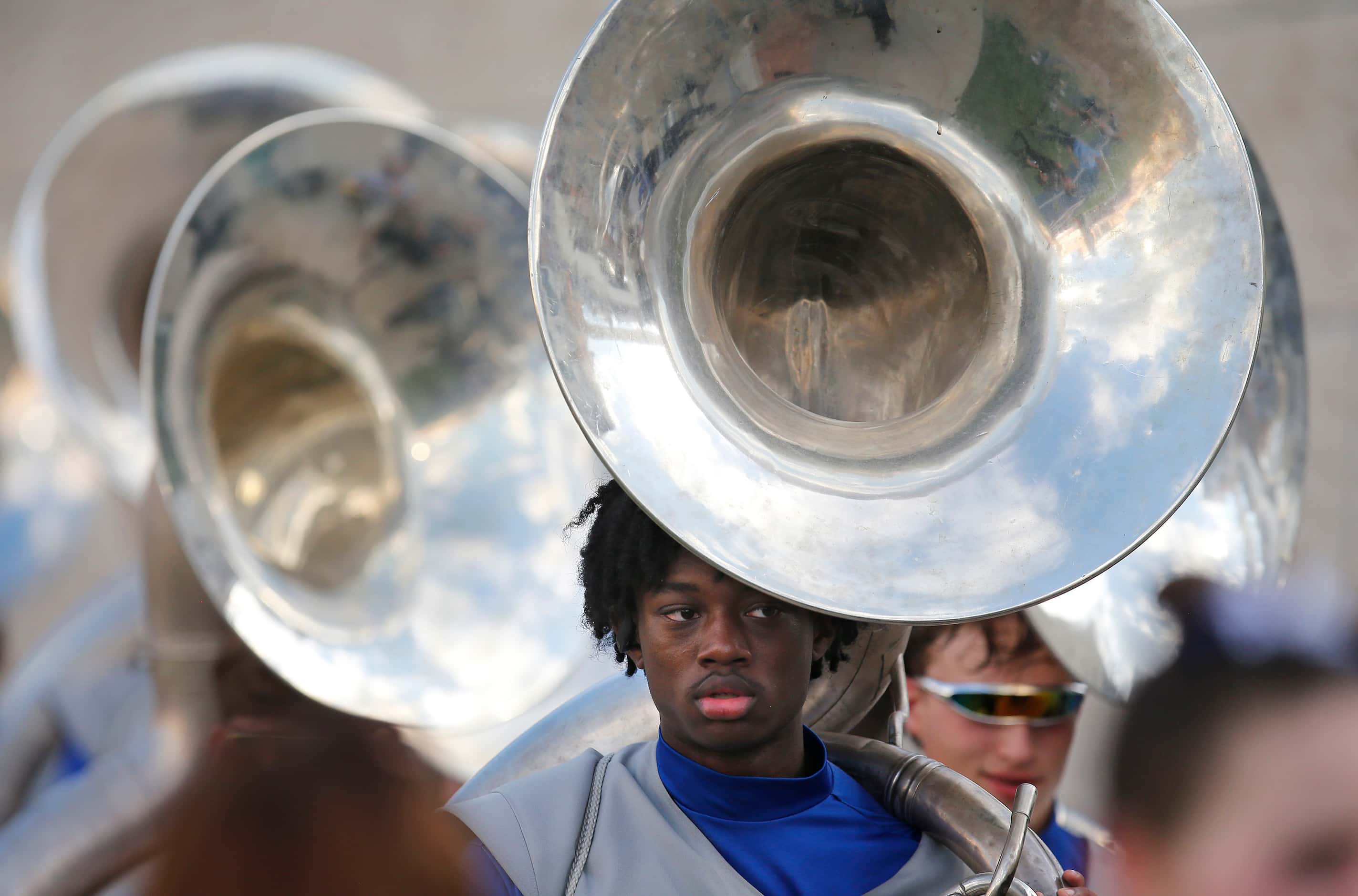 Allen High School marching band membr Renoll Morgan walks onto the field with his sousaphone...