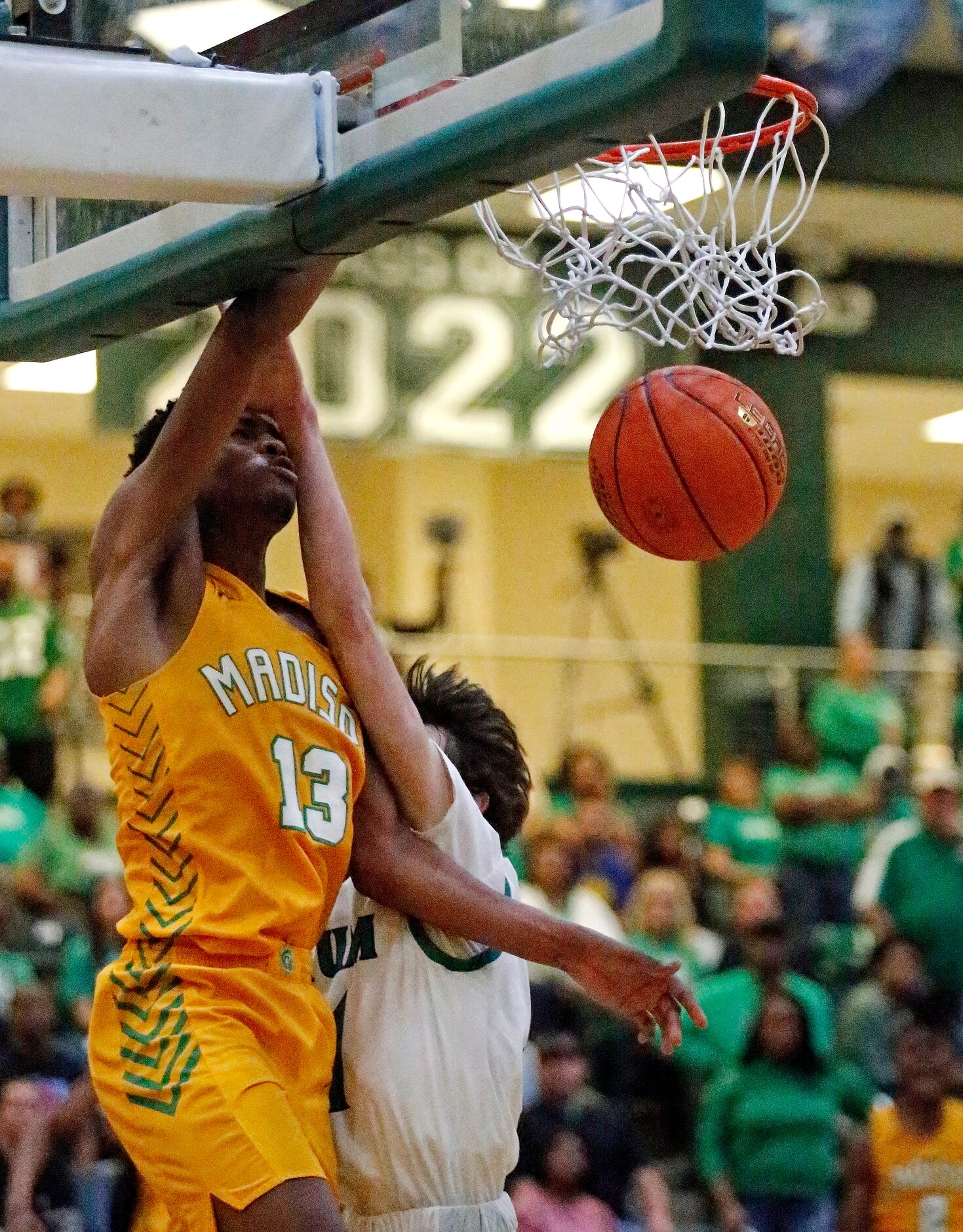 Madison forward Rodney Geter (13) makes a dunk as Tatum gaurd Aidan Anthony (11) defends...