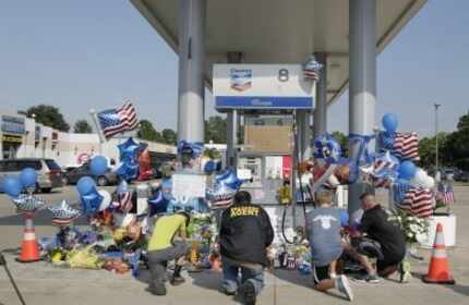  Mourners gather at a gas station in Houston on Saturday, Aug. 29, 2015 to pay their...