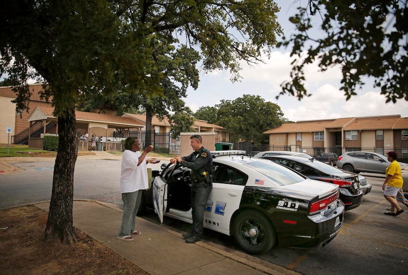 
Resident Gail Washington visits with Dallas police Officer Brandon Byrd outside the main...