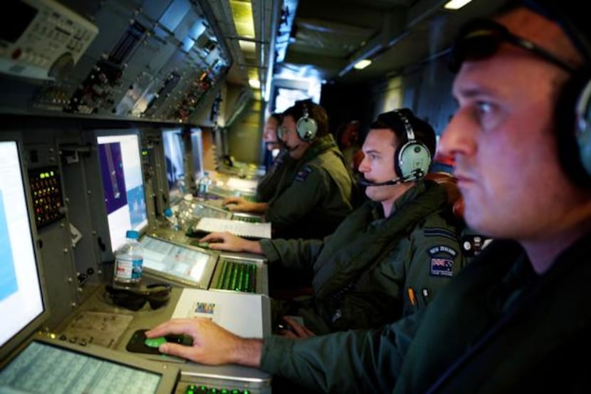 
Crew members of a Royal New Zealand Air Force P-3 Orion operate radar and sensor systems...