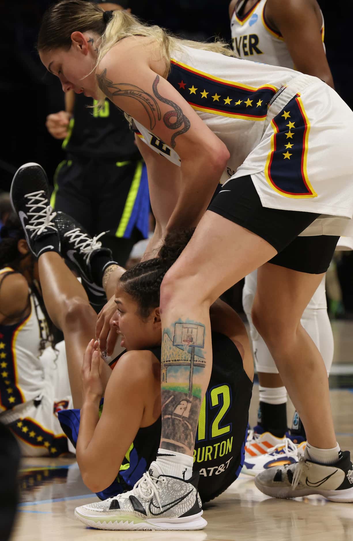 Dallas Wings guard Veronica Burton (12) fights to keep ball possession as she is challenged...