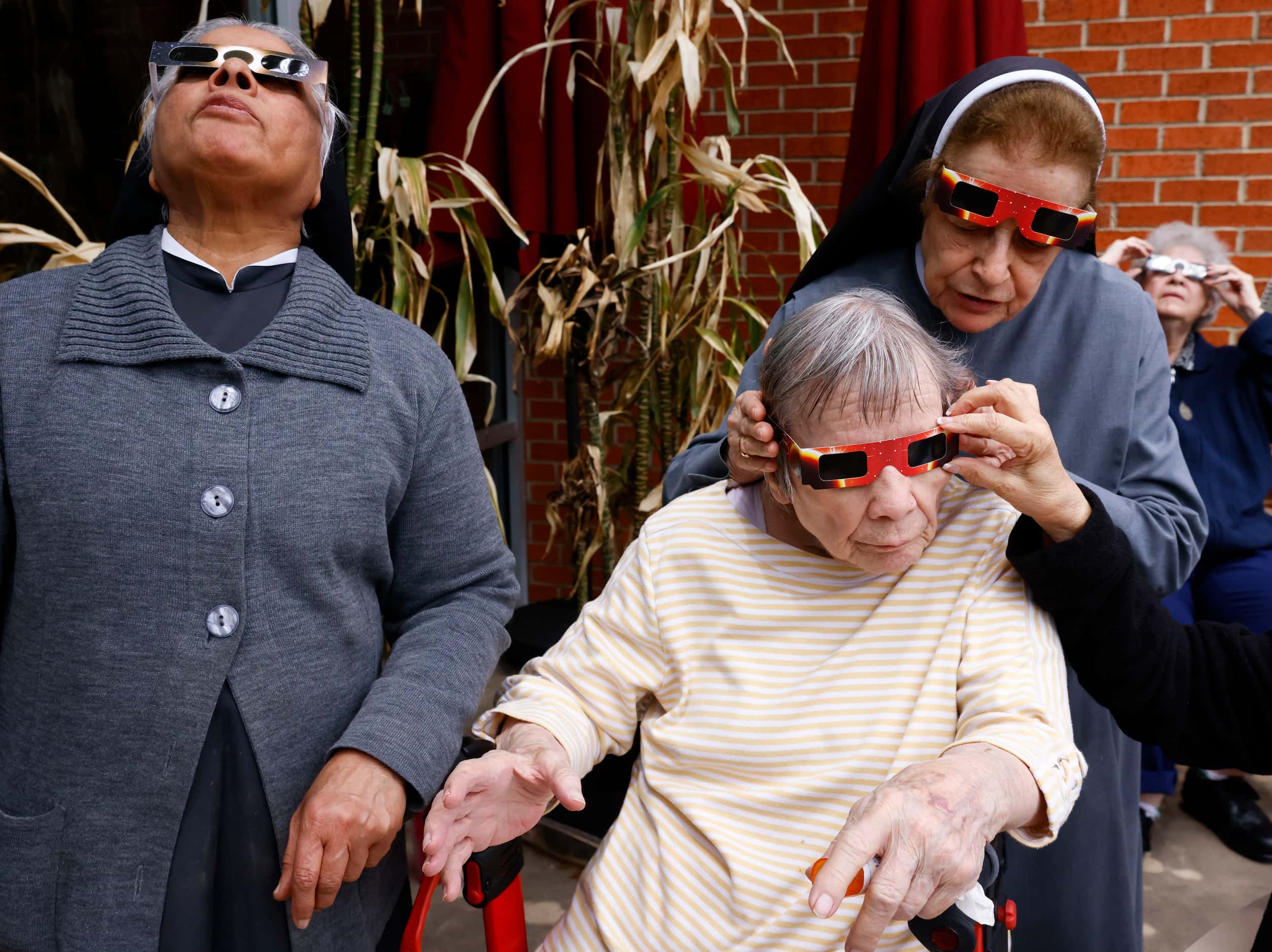 Sister Fatima Putti (left) looks up as sister Carolina Botero helps Marilyn Ehrlicher, with...