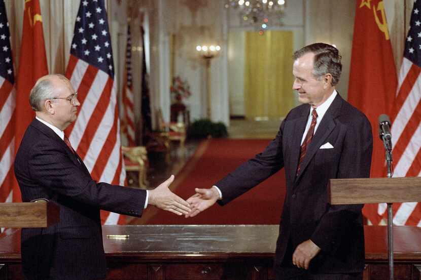 FILE - Soviet President Mikhail Gorbachev, left, and President George H. Bush shake hands...