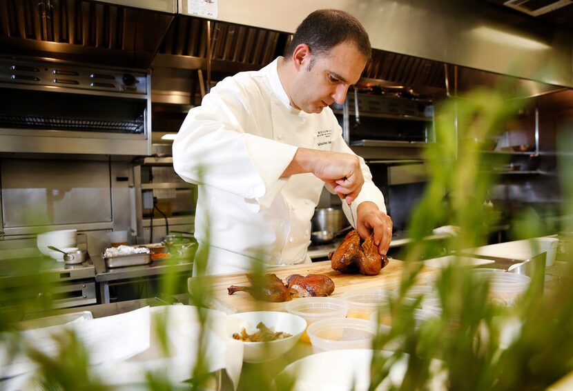 Executive chef Sebastien Archambault carves a roasted duck a l'orange