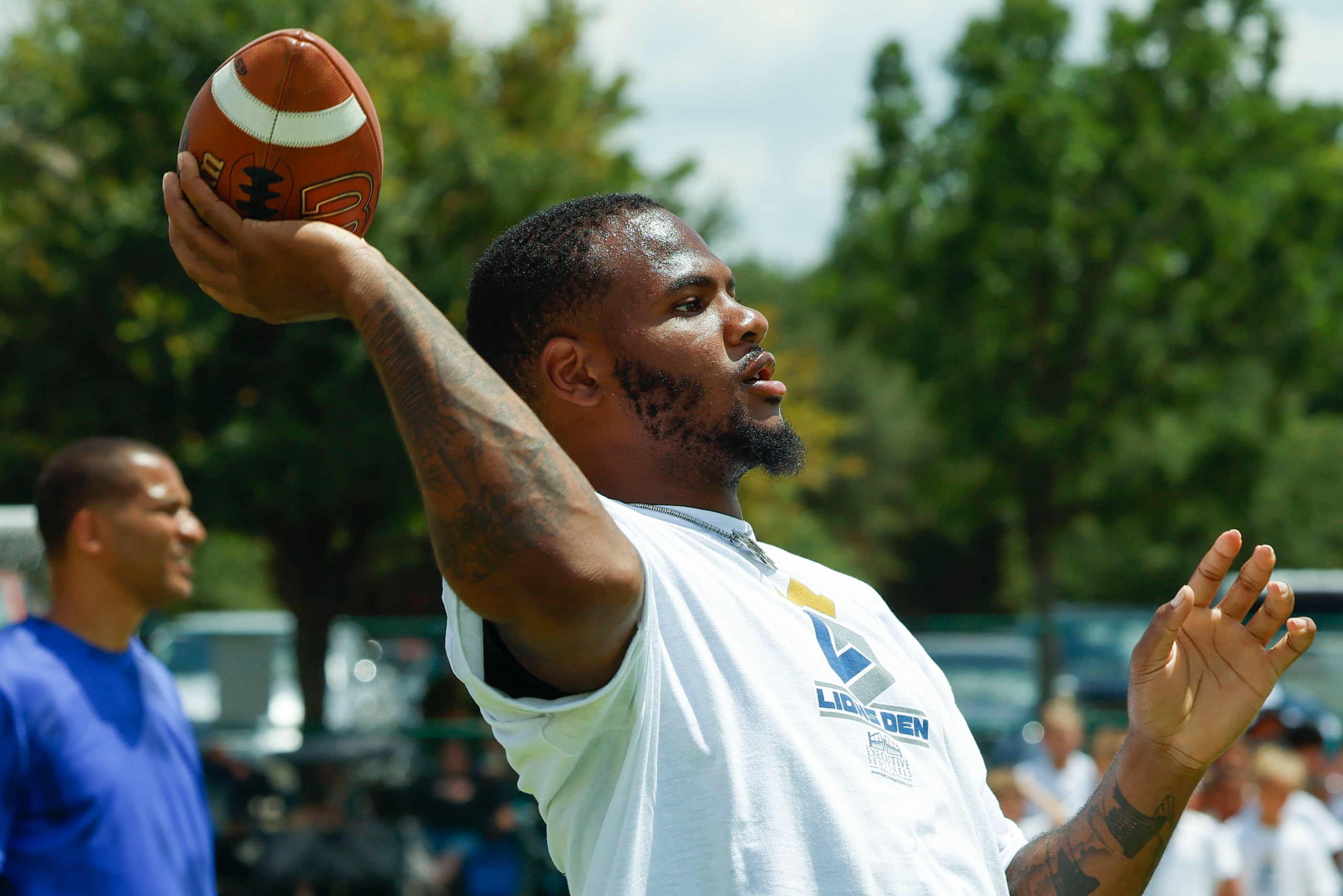 Dallas Cowboys linebacker Micah Parsons looks to throw the ball as he interacts with young...