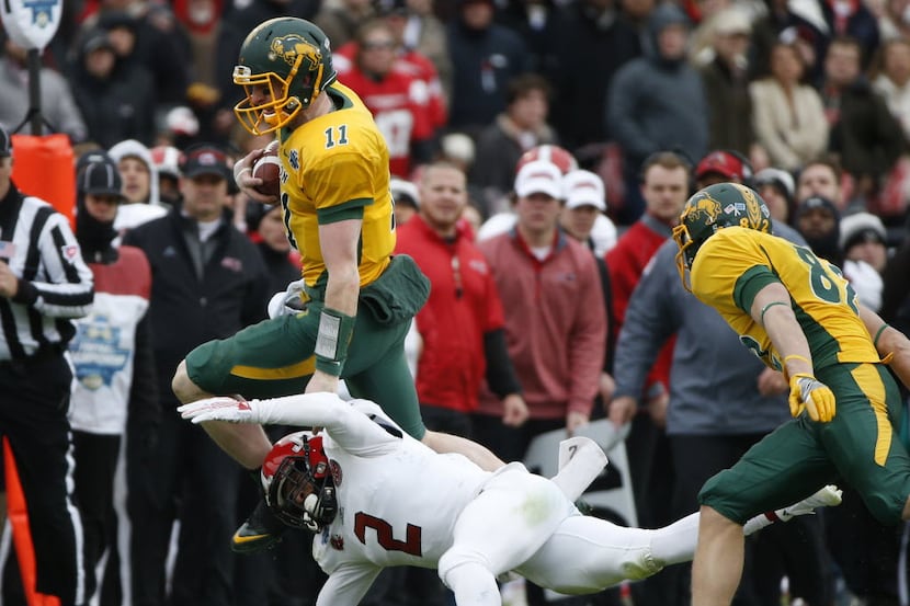 North Dakota State Bison quarterback Carson Wentz (11) jumps over Jacksonville State...