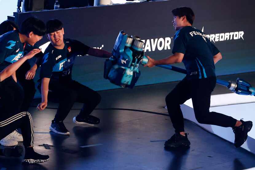 Dallas Fuel player Fearless (right) slams Reinhardt's hammer, knocking over his teammates...