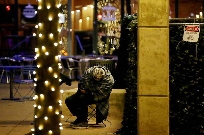 A homeless person in a chair in Pegasus Plaza in downtown Dallas in a file photo. ...