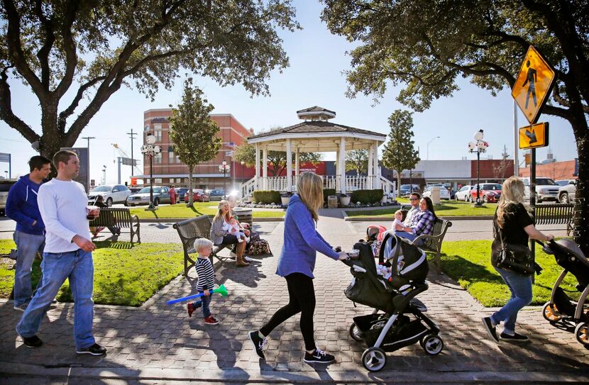 
Families with young children and babies stroll through historic downtown Carrollton on a...