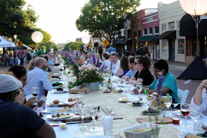 Guests eat and drink food prepared by Cafe Momentum students at Night Out on 15th Street in...