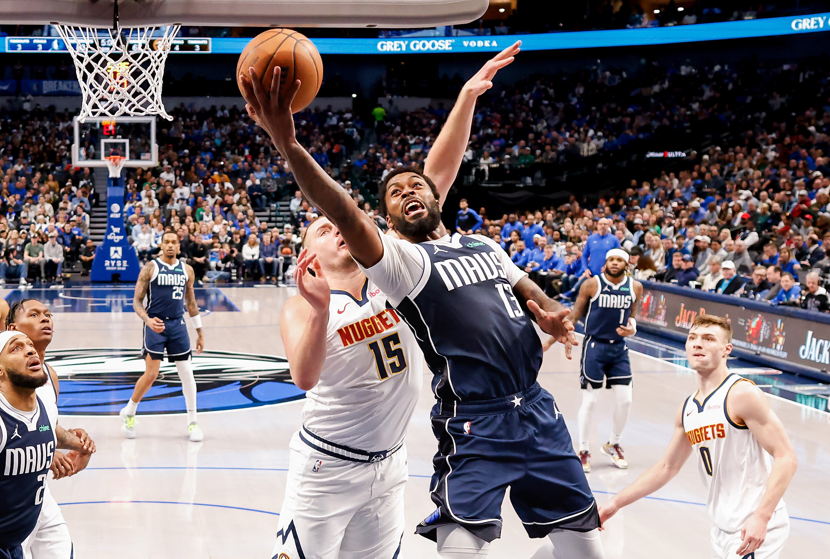 Dallas Mavericks forward Naji Marshall (13) drives to the basket as Denver Nuggets center...