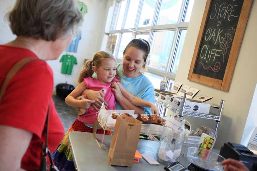 Kelcie Koerner holds her daughter Elizabeth, 5, as she picks out a pastry at Urban Acres.