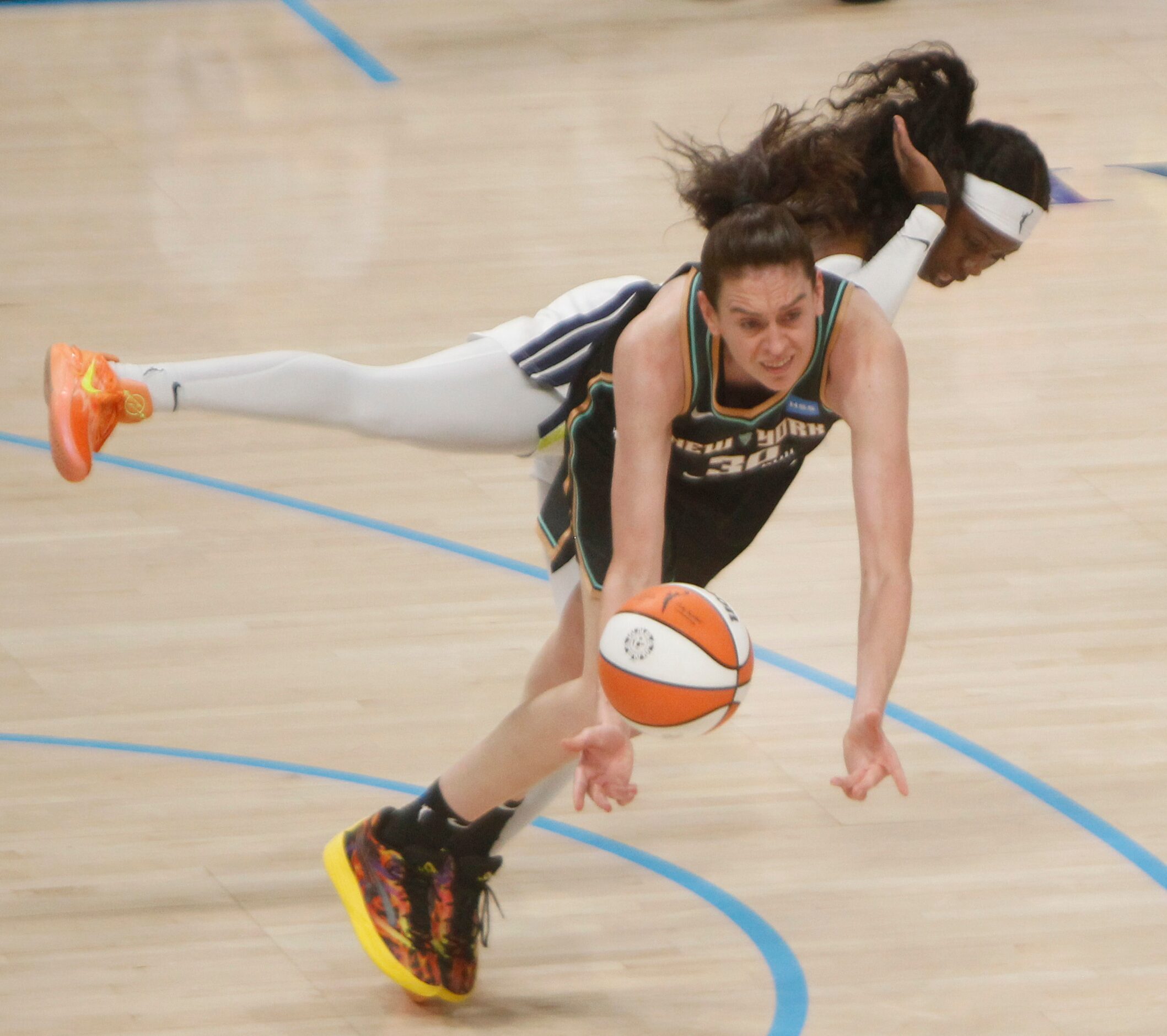 Dallas Wings guard Arike Ogunbowale (24), background, collides with New York Liberty forward...