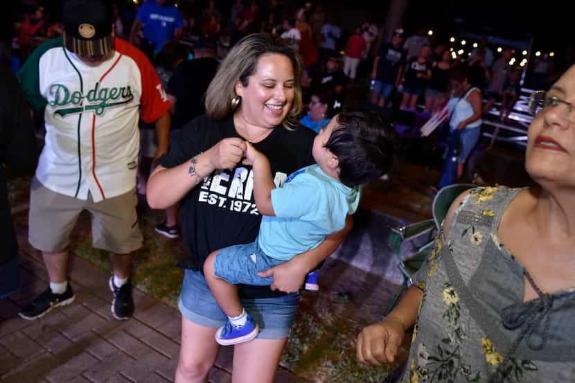 A woman dances with a child to the sounds of Los Angeles band Tierra during the 2019 Latino...