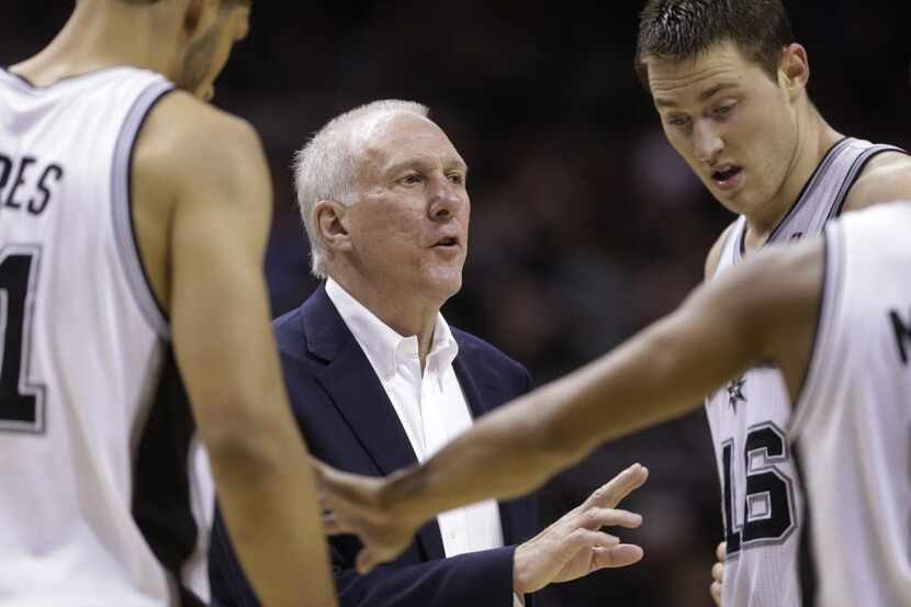 San Antonio Spurs head coach Gregg Popovich, center, talks with Aron Baynes, right, and Jeff...