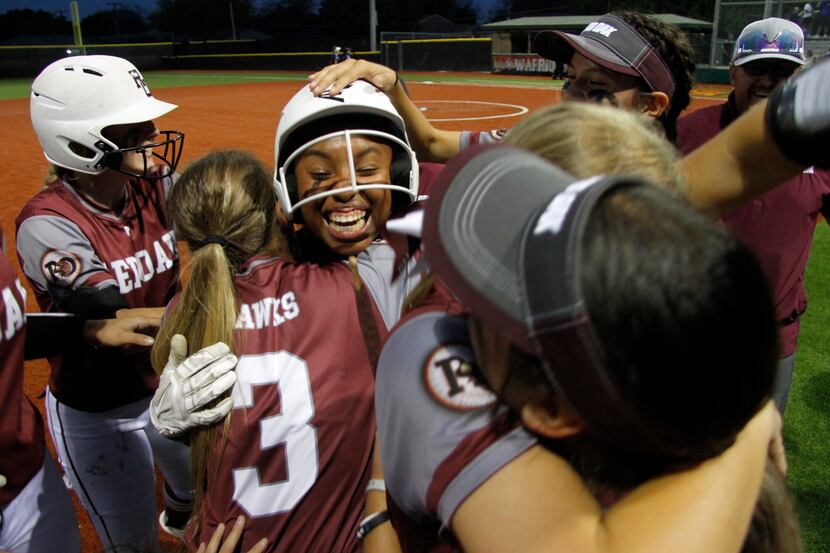 Brianna Evans (center) is mobbed by teammates after her walk-off run-scoring hit in the...