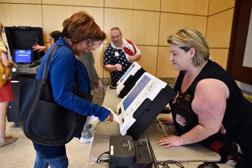 Constancia Shaw (left) uses the new Express Vote machine with help from Dallas County...
