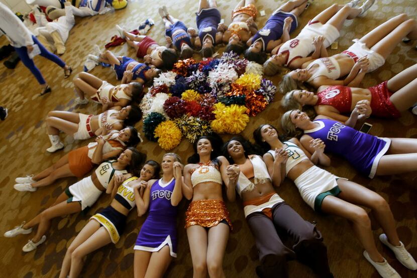 Cheerleaders circle up for a photo during the Big 12 college football media days in Dallas,...