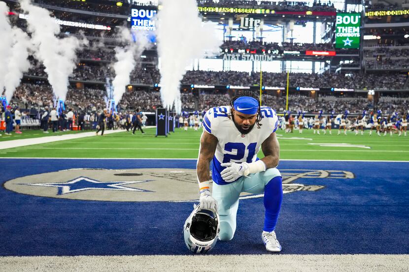 Dallas Cowboys running back Ezekiel Elliott (21) kneels on the field before an NFL football...