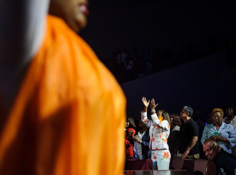 Alicia Williams, bottom right orange, sings in worship during the final scene during at Oak...